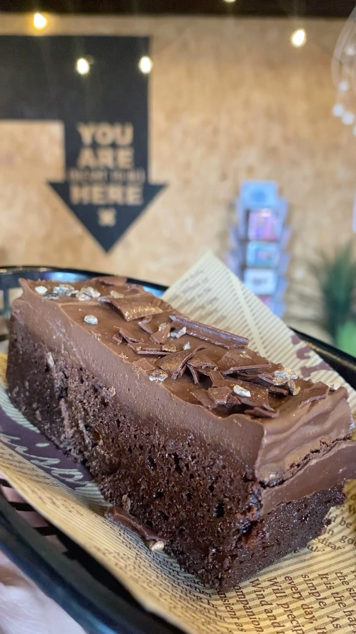 A slice of chocolate fudge cake with chocolate shavings
