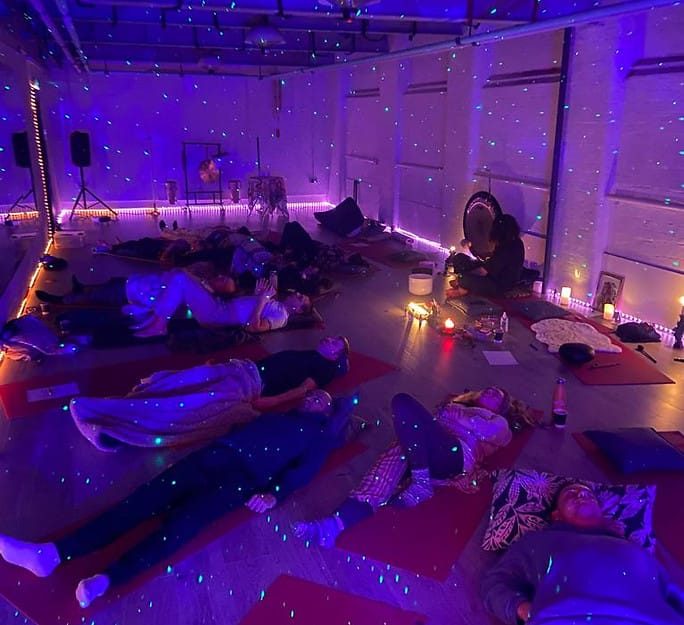 A candlelit sound bath with participants lying on mats